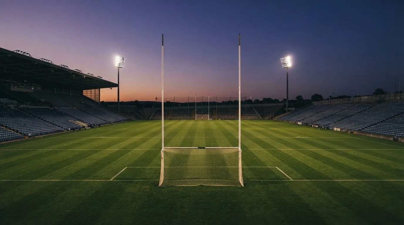 An empty football stadium with floodlight masts at dusk