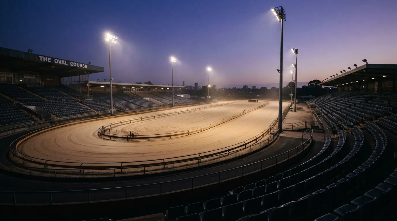 An empty football stadium with floodlight masts at dusk