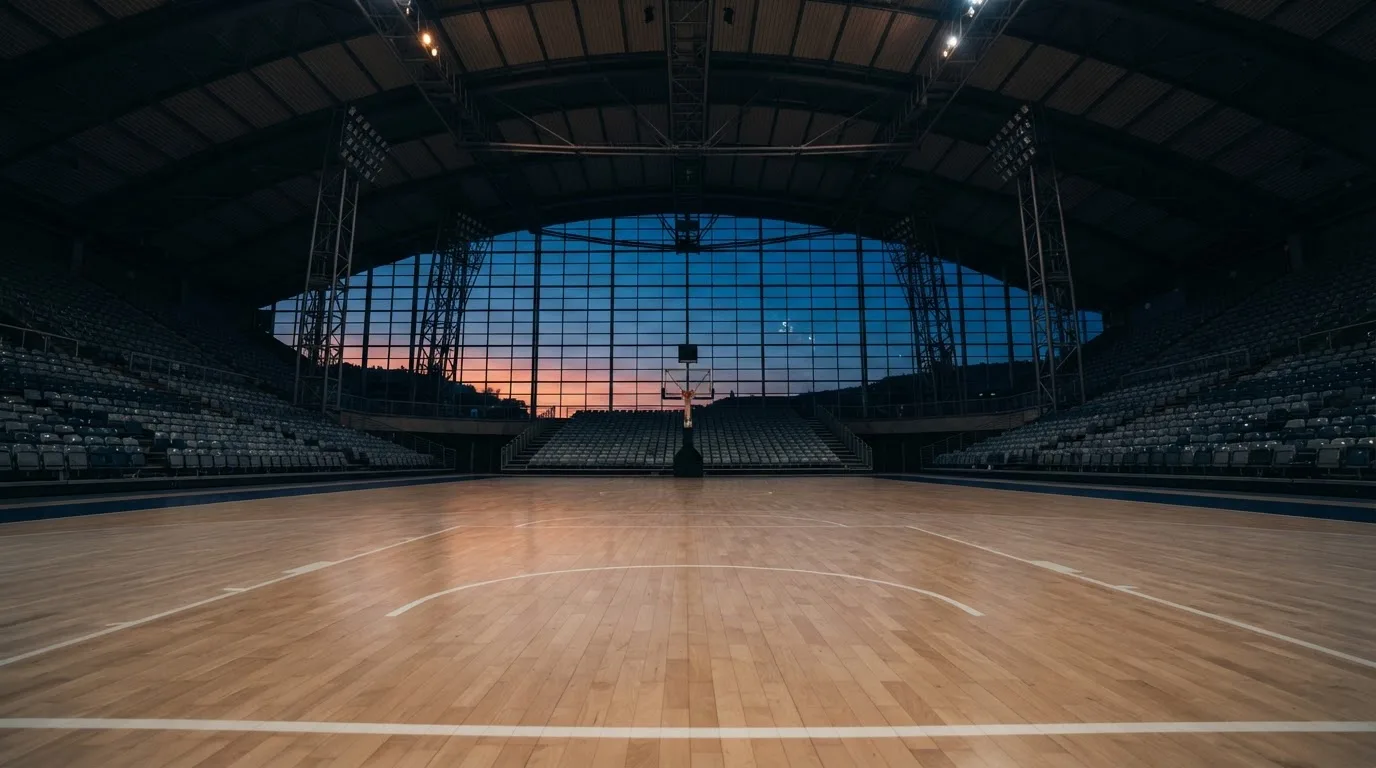 An empty football stadium with floodlight masts at dusk