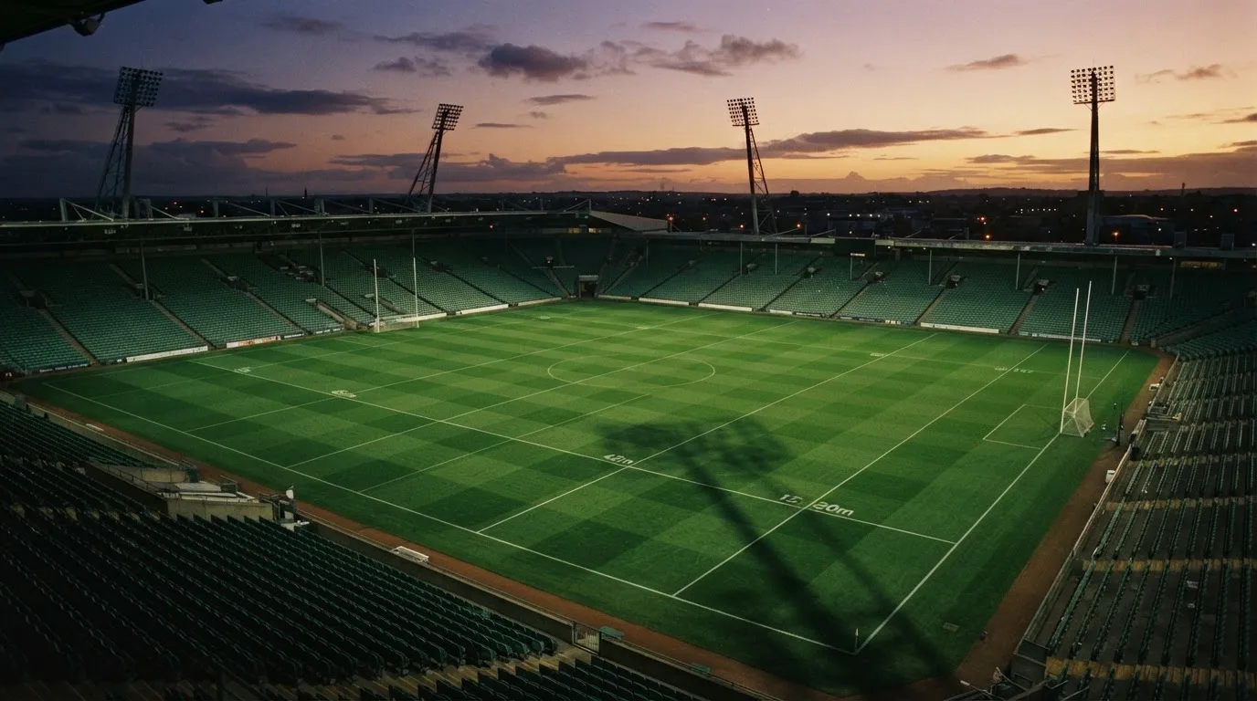 An empty football stadium with floodlight masts at dusk