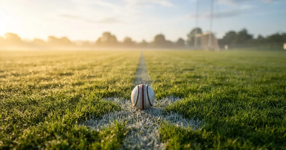 A ball on the centre spot of a grass pitch in morning light