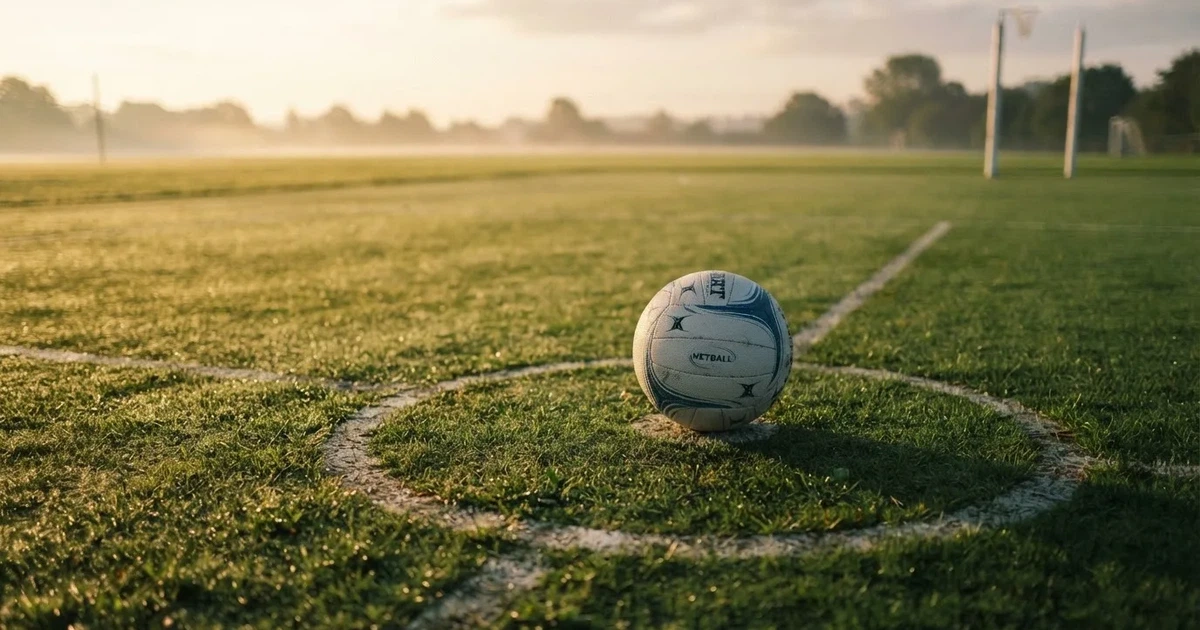 A ball on the centre spot of a grass pitch in morning light